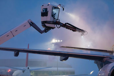 Deicing of airplane before flight. winter frosty night and ground service at airport.