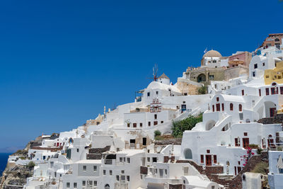 Panoramic view of oia town in santorini island with old whitewashed houses and  windmill, greece