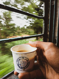 Close-up of hand holding coffee cup