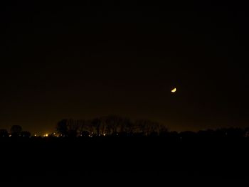 Silhouette landscape against sky at night