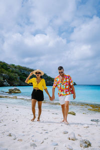 Portrait of couple holing hands walking at beach