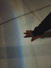 High angle view of hand on multi colored shadow