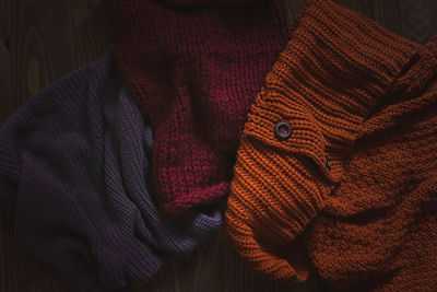 Knitted scarves on a wooden background, the concept of autumn and warm clothes