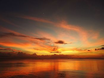 Scenic view of sea against dramatic sky during sunset