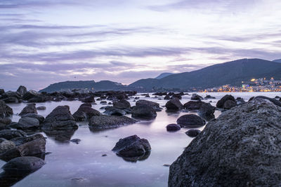 Rocks by sea against sky