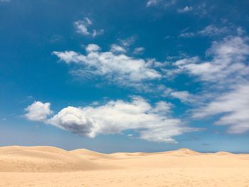 Scenic view of desert against blue sky