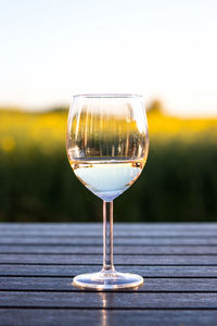 Close-up of wineglass on table against sky