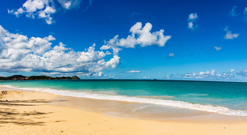 Scenic view of beach against blue sky