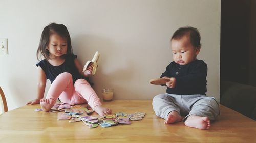 Siblings playing with toys on table