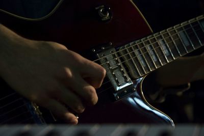 Close-up of hand plucking guitar