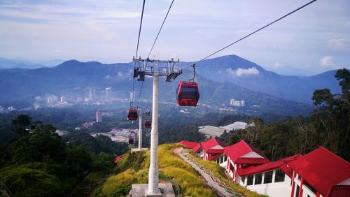 Overhead cable car over mountains against sky