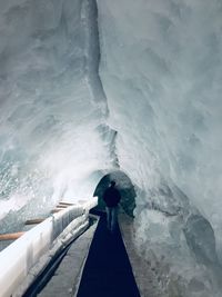 Rear view of people standing on snow covered shore
