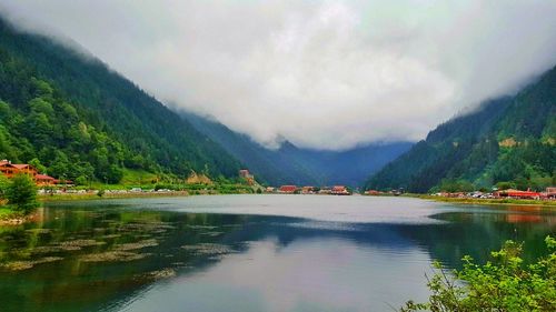 Scenic view of lake by mountains against sky