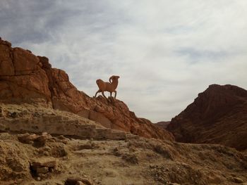 Low angle view of rocks on mountain against sky