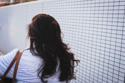 Woman by wall in city