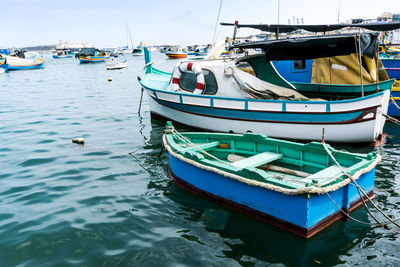 Boats moored at harbor against sky