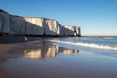 Built structure on beach against clear blue sky