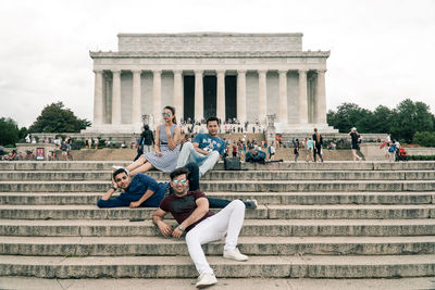 People sitting on steps of historical building
