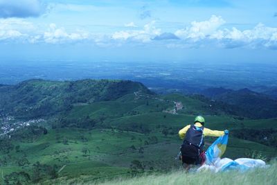 Man paragliding on mountain against sky