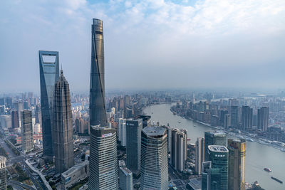 Modern buildings in city against cloudy sky