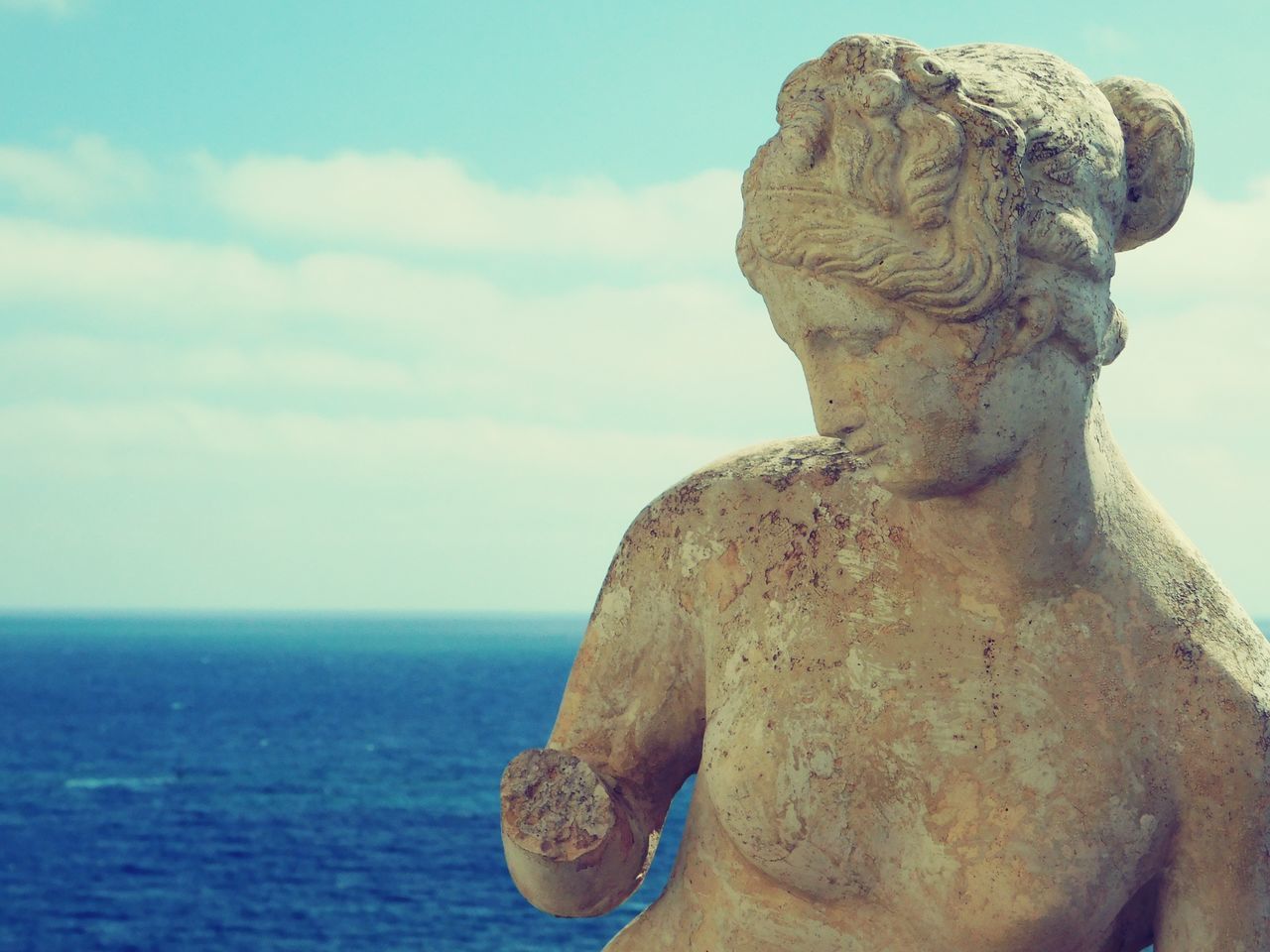 CLOSE-UP OF STATUE AGAINST SEA AGAINST SKY