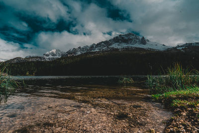 Scenic view of lake by mountains against sky