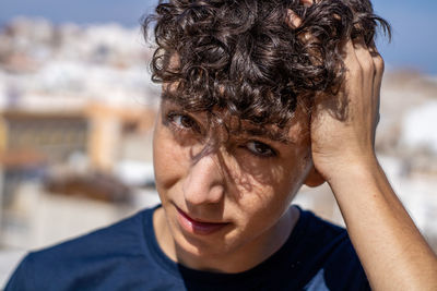 Close-up portrait of man with hand in hair