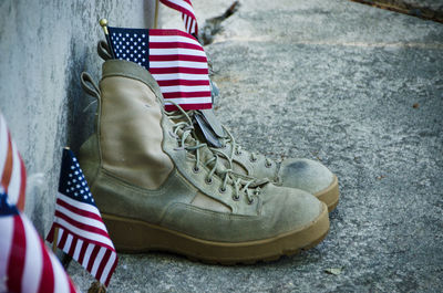 Close-up of shoes with american flags on footpath