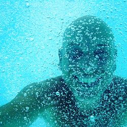 Close-up portrait of man swimming underwater