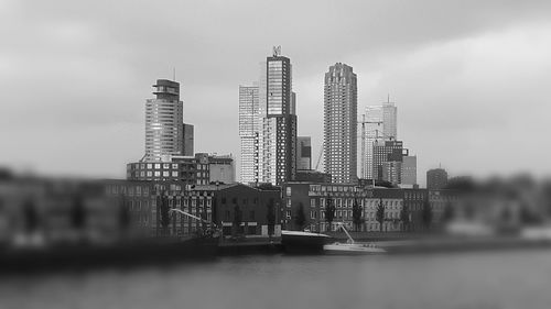 View of skyscrapers in city against cloudy sky