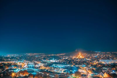 High angle view of illuminated cityscape against sky at night