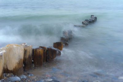 View of wooden posts in sea