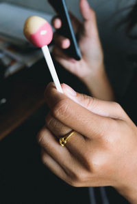 Cropped hand of woman holding lollipop