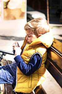 Boy holding while sitting outdoors