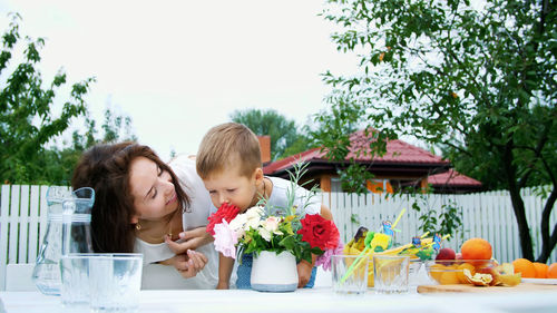 Summer, in the garden. mom with a four-year-old son make a bouquet of flowers. the boy likes it