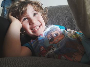 Portrait of cute boy smiling on sofa at home