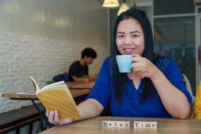 Portrait of young woman drinking coffee