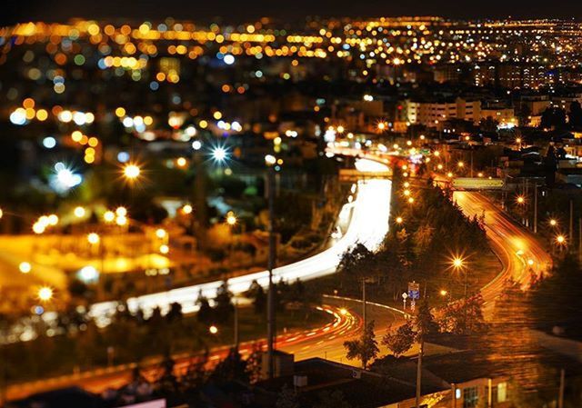 illuminated, night, city, transportation, building exterior, architecture, high angle view, built structure, cityscape, road, light trail, city life, street, lighting equipment, traffic, street light, light - natural phenomenon, no people, city street, outdoors