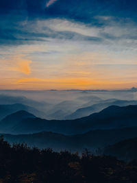 Scenic view of silhouette mountains against sky at sunset