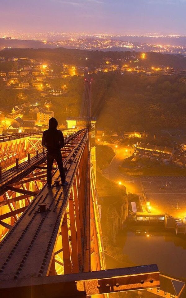 city, illuminated, transportation, architecture, built structure, sunset, high angle view, night, cityscape, city life, building exterior, lifestyles, men, bridge - man made structure, on the move, mode of transport, travel, leisure activity, connection