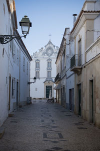 Church against clear blue sky seen from alley