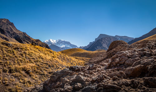 Scenic view of mountains against clear blue sky