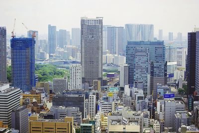 Aerial view of buildings in city against sky