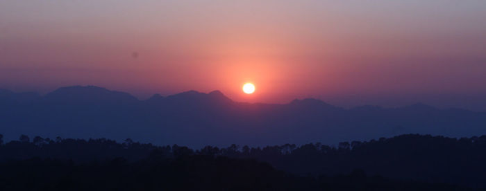 Scenic view of silhouette mountains against sky during sunset