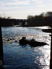 Scenic view of river against sky at sunset