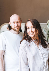 Portrait of smiling friends standing against wall