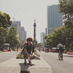 Full length of young man with sculpture in city