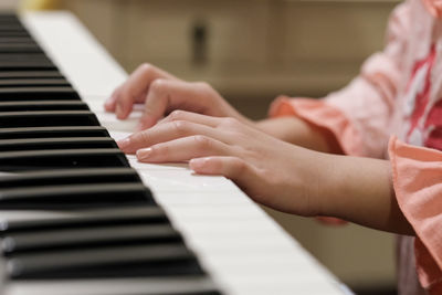 Midsection of person playing piano