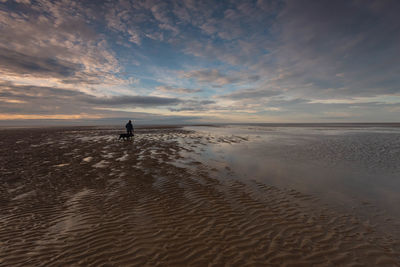 Silhouette man on beach against sky