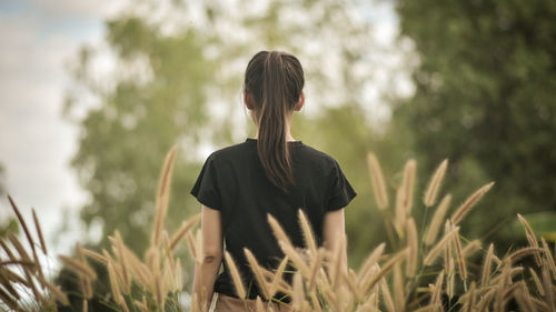 Rear view of woman standing in farm